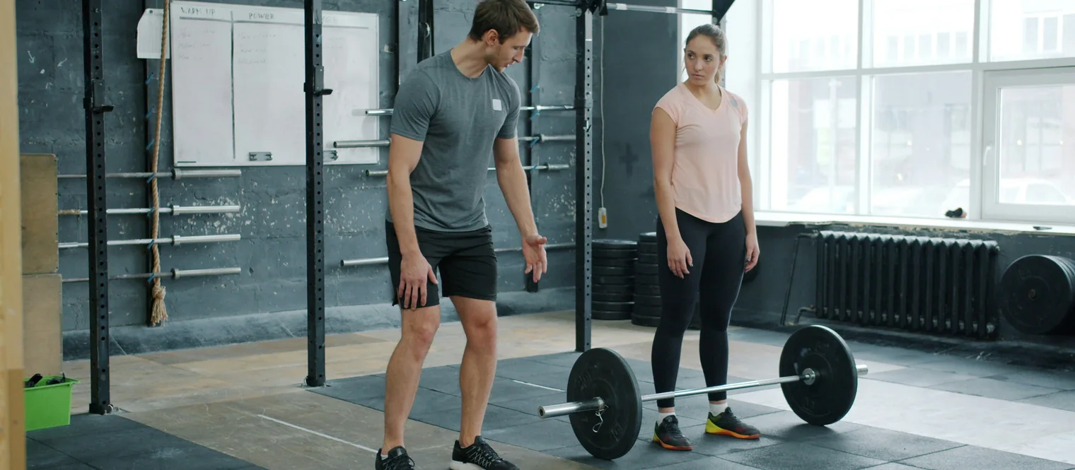 A trainer helping a student at the gym