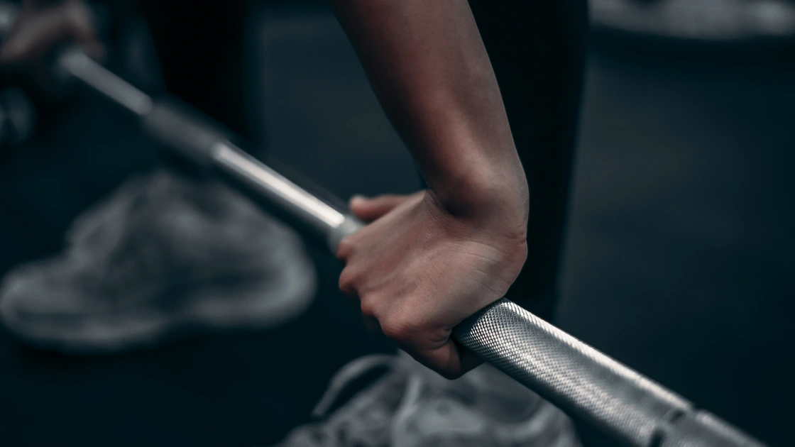Hands gripping a barbell.