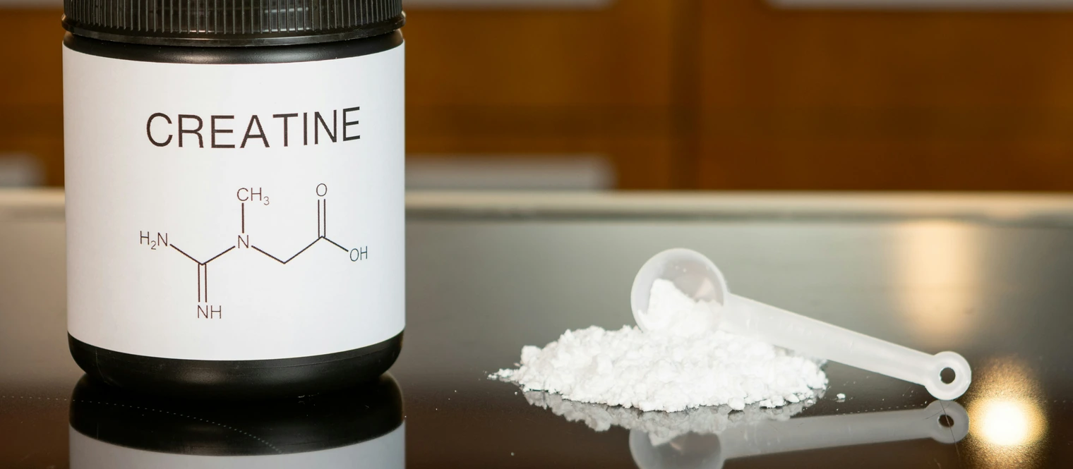 Creatine powder on a counter with a scoop