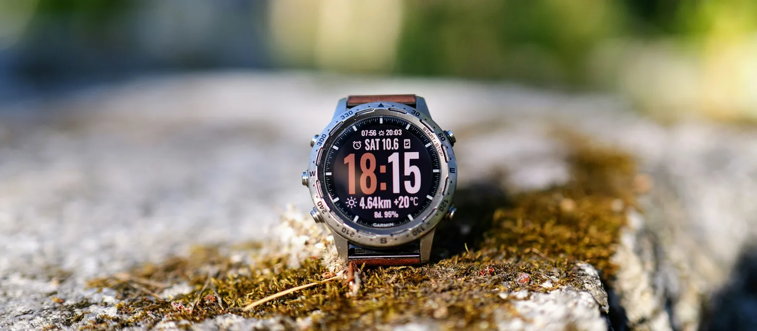 A Garmin watch resting on a rock
