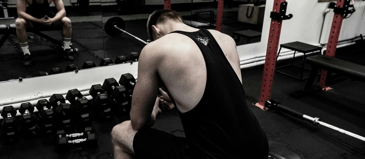 A man sitting on a bench between sets