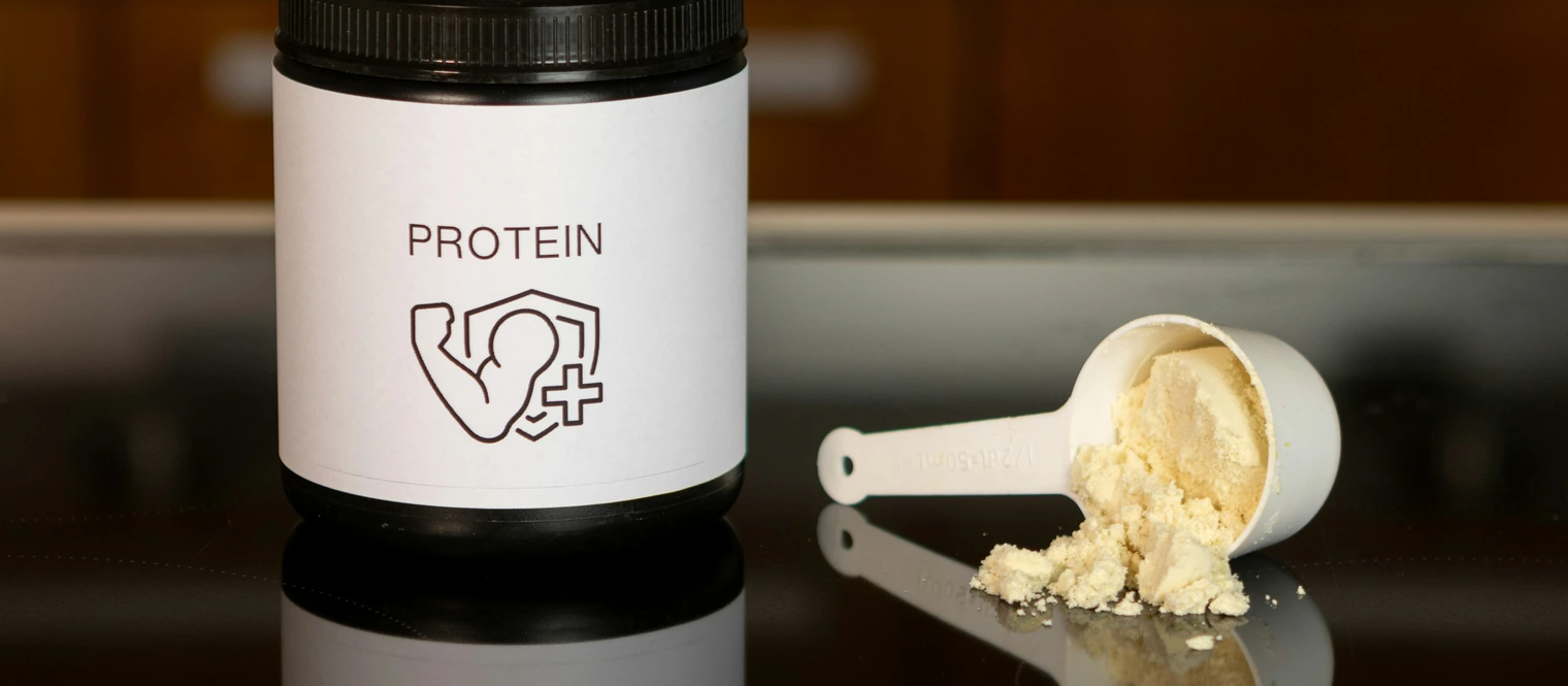 Protein powder on a counter with a scoop