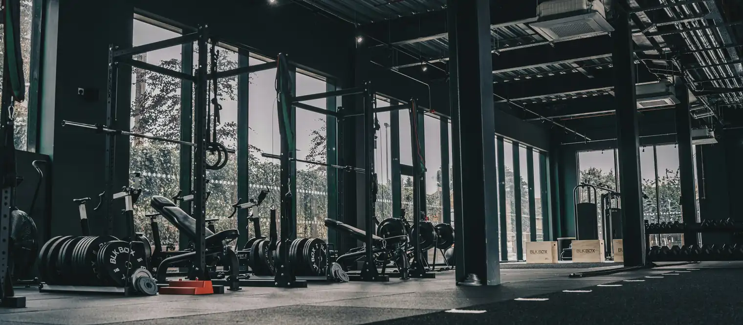 A commercial gym with bench bars and ropes 