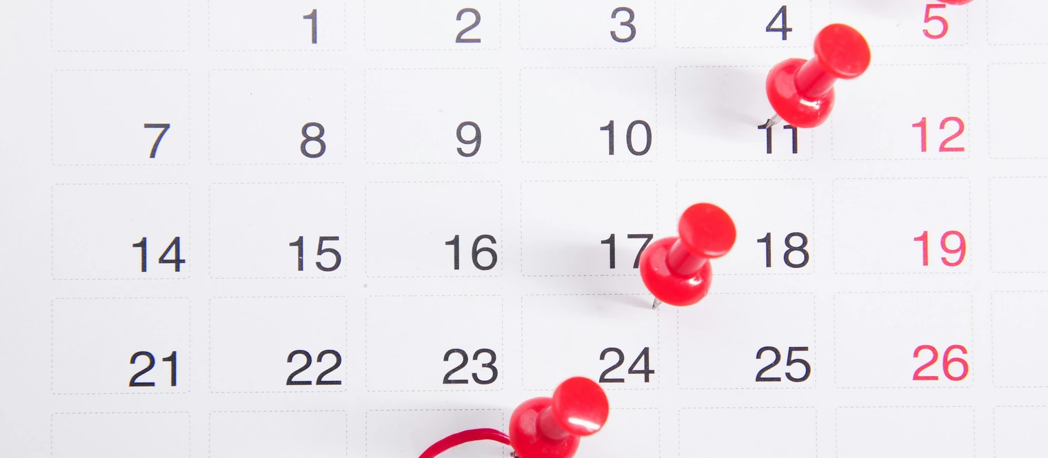 A calendar with push pins